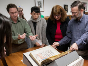 Special Collections Librarian Jeremy Dibbell, left, discusses a recent acquisition, The Gradual of La Crocetta, with a group of students and faculty.
