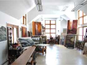 An art studio with bright light shining from above with a figure in the background