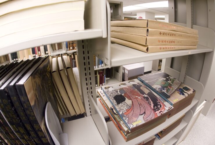 Several items stacked on shelves of Special Collections