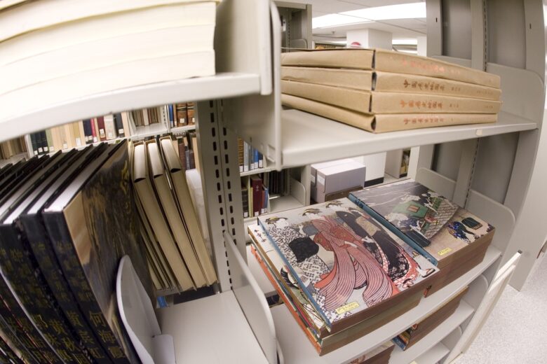 Several items stacked on shelves of Special Collections