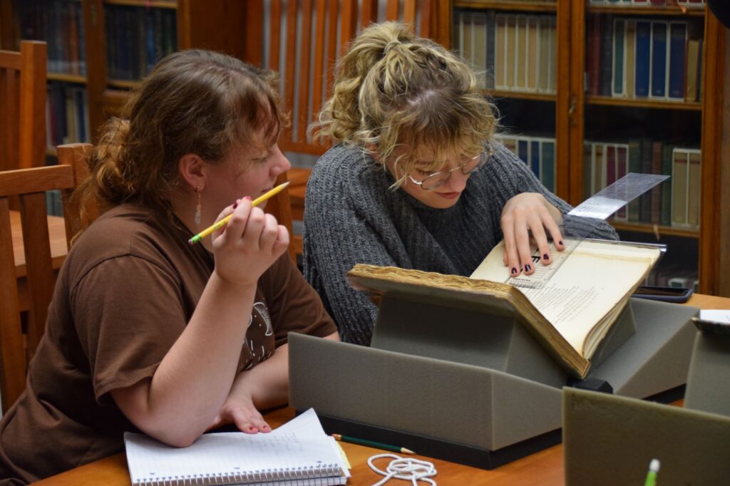 Students examine a book in ARTS 315