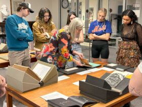 Students in ARTS 360 examine books in Special Collections