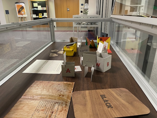 Photograph of exhibit case with book arts items on display