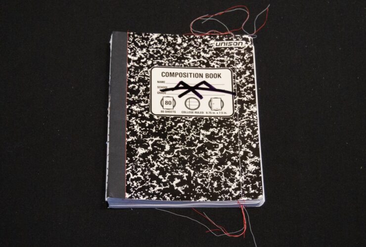 Cover of Alexander Schambach's "Composition, Vol. 1," showing a black and white mottled composition book on a black background, with multi-colored threads at the edges of the book.