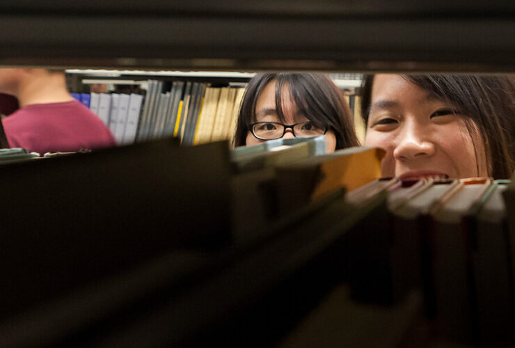 A student peeks through the shelves of the Bartle stacks