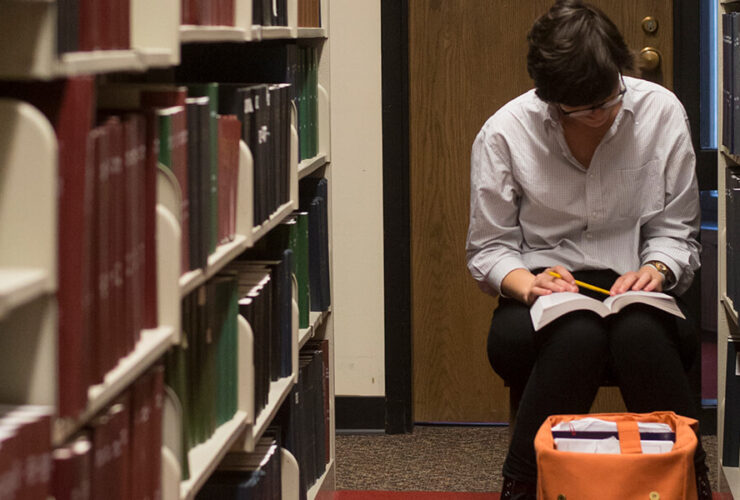 A student studies a book among the Bartle stacks