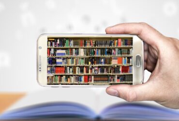Hand holding phone with image of book shelves