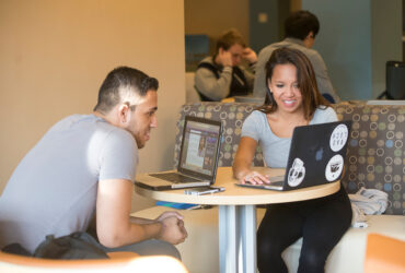 Two Binghamton students studying with laptops