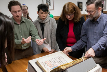 Special Collections Librarian Jeremy Dibbell, left, discusses a recent acquisition, The Gradual of La Crocetta, with a group of students and faculty.