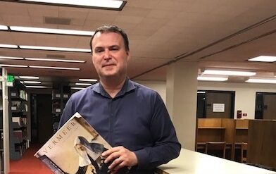 Jim Galbraith, the Libraries' Head of Collection Development, poses in the Fine Arts stacks in Bartle Library
