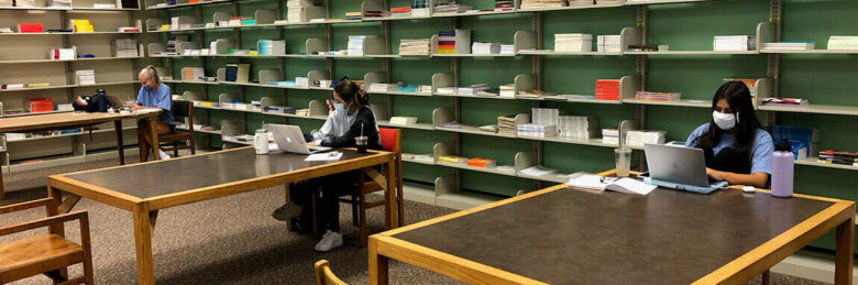 Masked student workers in a socially distanced manner in the Libraries