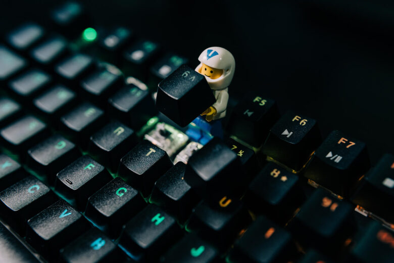 A lego minifigure is posed as if it is removing a key from a keyboard