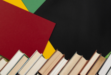 red, yellow, green, and black background with stacked books at the bottom