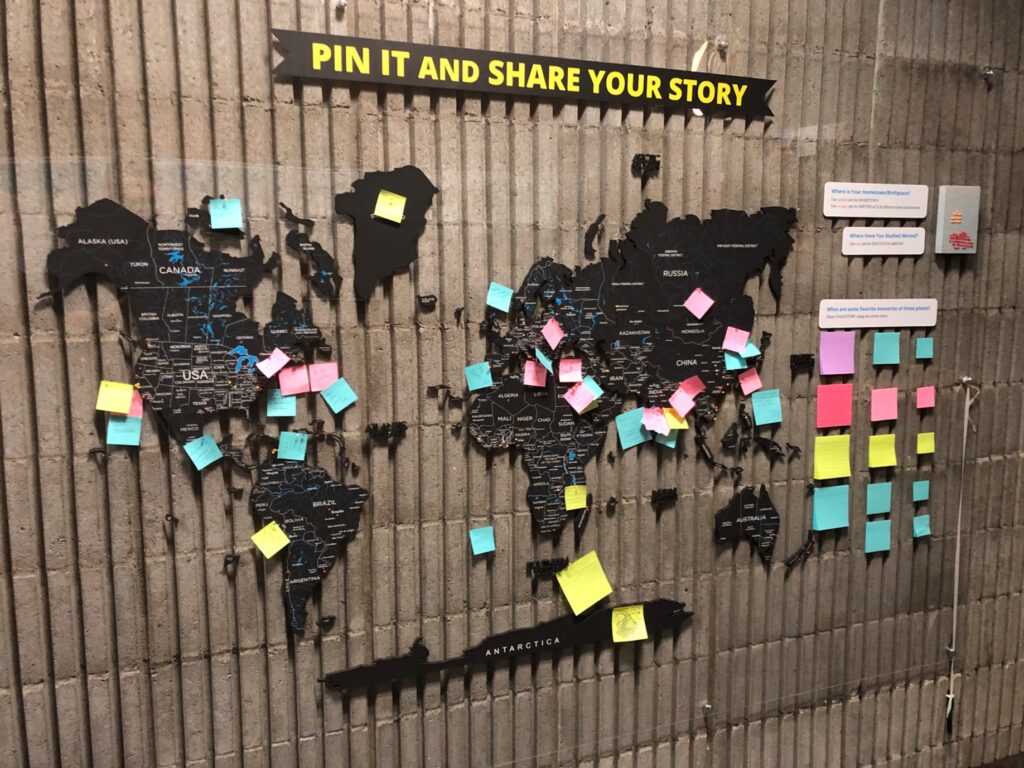 A world map displayed on the wall with various pins and sticky notes share student experience with studying abroad