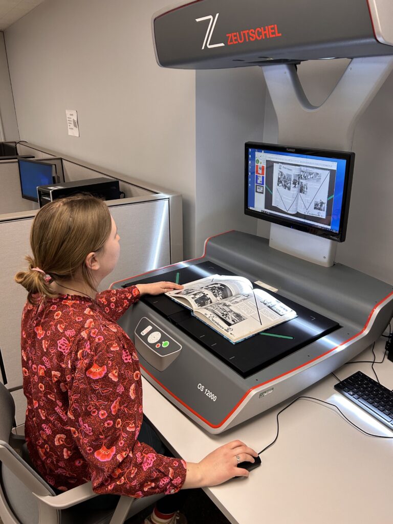 Caitlin Holton, digital initiatives assistant, scans a yearbook to be added to the digitized collection.