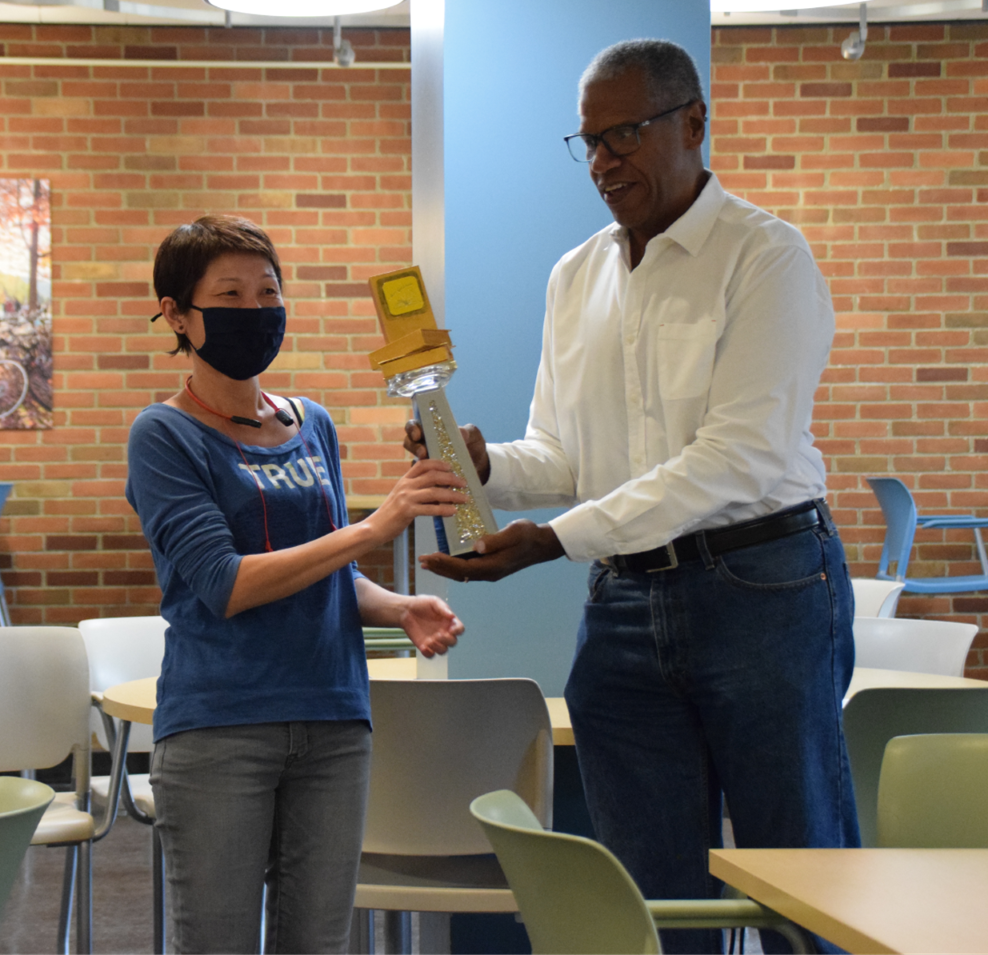 Photo of Mien Wong receiving the Golden Book Award statue from Former Dean of Libraries Curtis Kendrick.