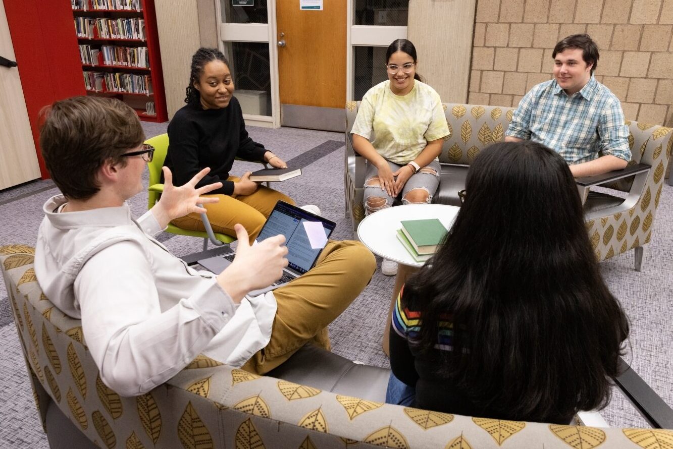 a group of students sit in a circle in the Science library and talk
