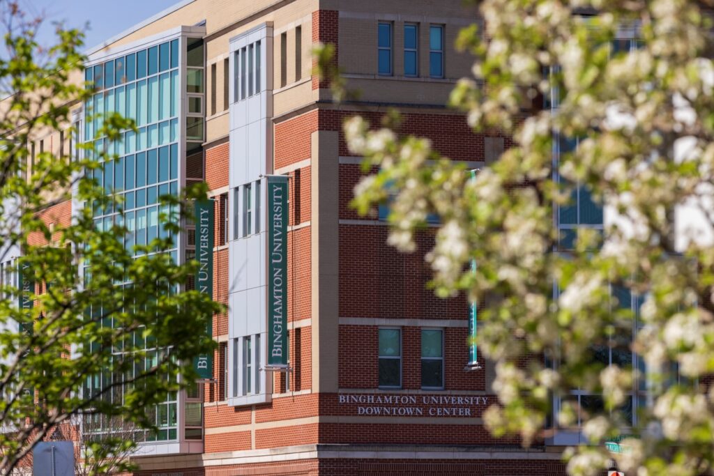 exterior photo of the Binghamton University Downtown Center amongst trees