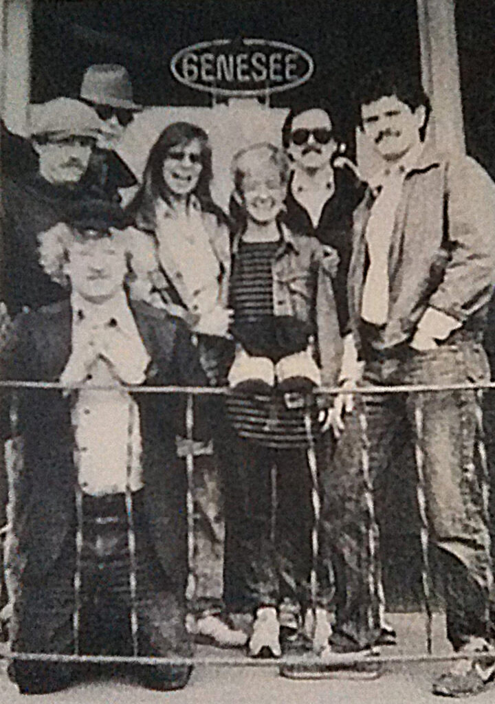 A photograph of a group of seven people of the Binghamton Community Poets taken at Swat Sullivan's Hotel in Binghamton, N.Y.