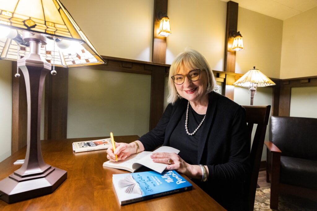 Alumna Molly Peacock, '69, signing a book in the newly opened Secret Poetry Room