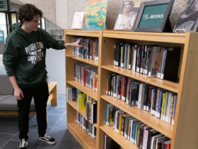 Student looks at the new book shelf in Bartle Library.