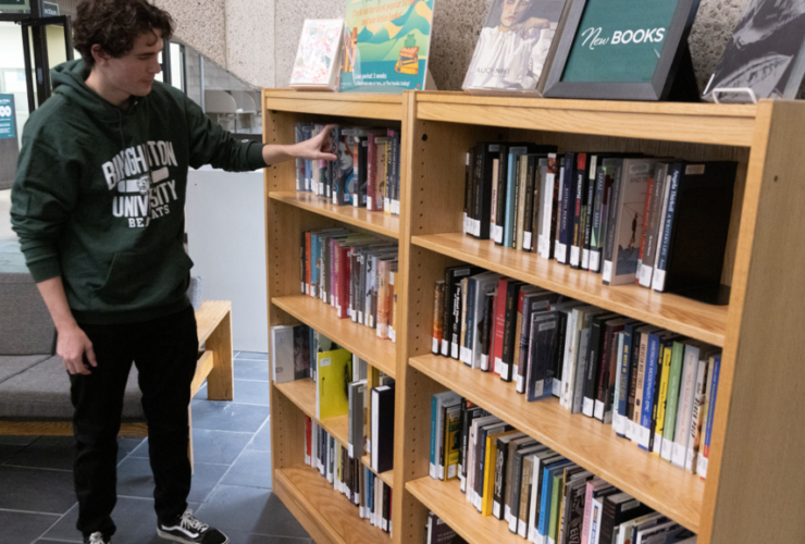 Student looks at the new book shelf in Bartle Library.