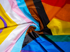 Photo of an intersex-inclusive progress pride flag swirled as it lays on a flat surface.