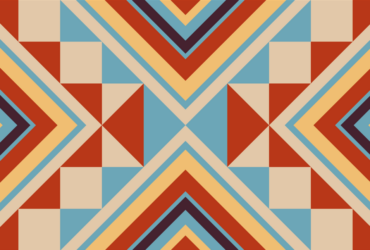 Decorative Native American inspired pattern featuring orange, blue and tan triangles of various sizes.