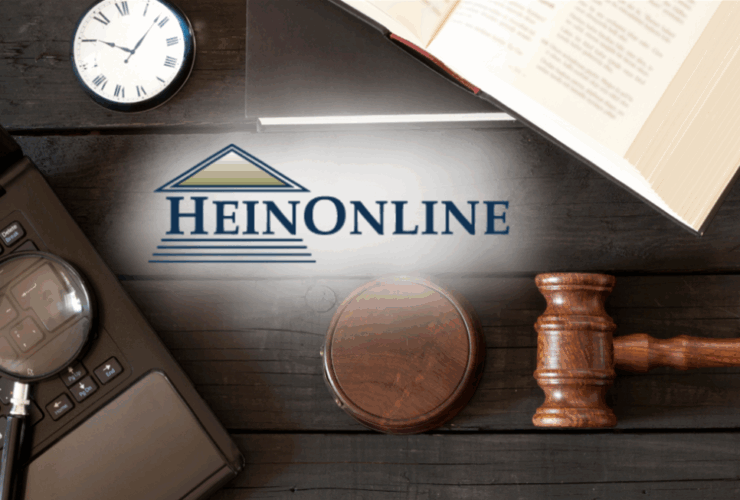 photo of law textbook, gavel and computer with a magnifying glass on top of a table. Text overlay includes the HeinOnline logo.