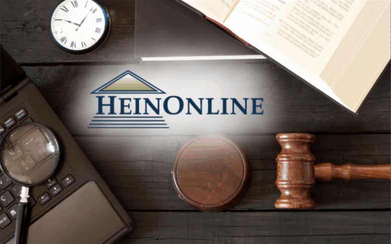 photo of law textbook, gavel and computer with a magnifying glass on top of a table. Text overlay includes the HeinOnline logo.