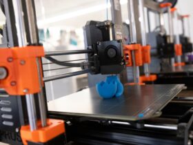 3D printer creates a figurine out of blue filament