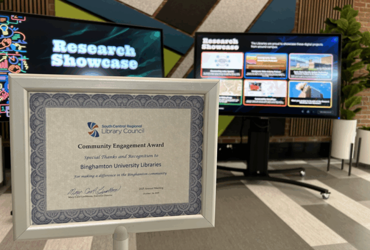 photo of Community Engagement Certificate displayed in front of the Research Showcase touchscreen displays.