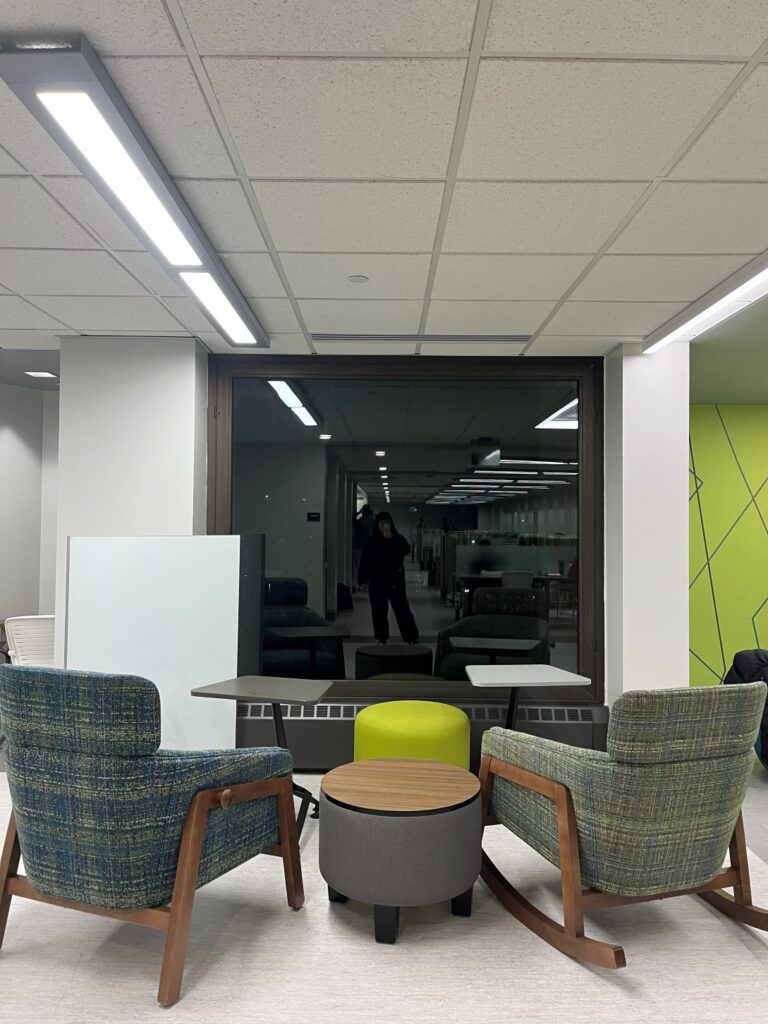 Photo of two rocking chairs with small desks looking out a window on the third floor of Bartle Library.