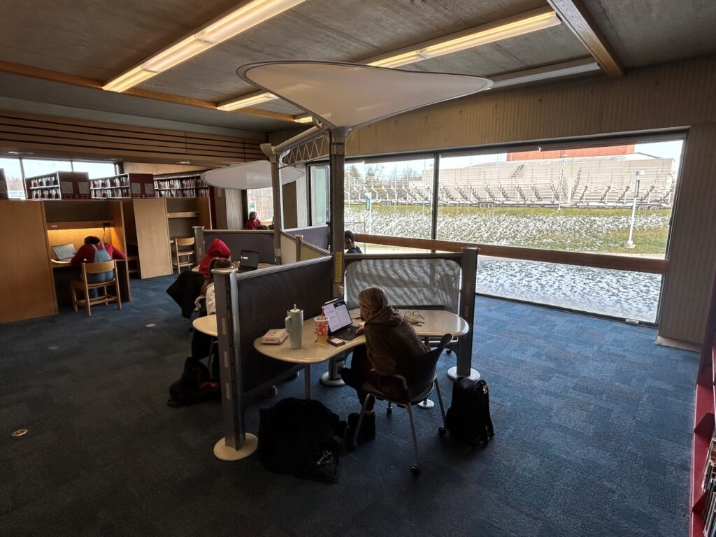 various study cubicles near a large window looking outside.
