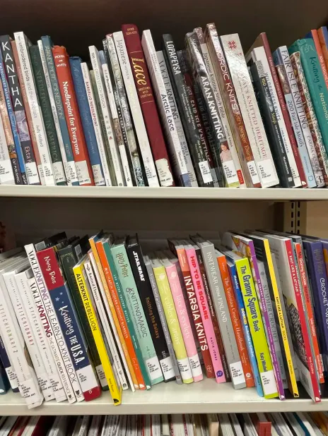 a variety of books of different colors and sizes on a shelf in Handicraft collection in the Fine Arts Collection of Bartle Library.