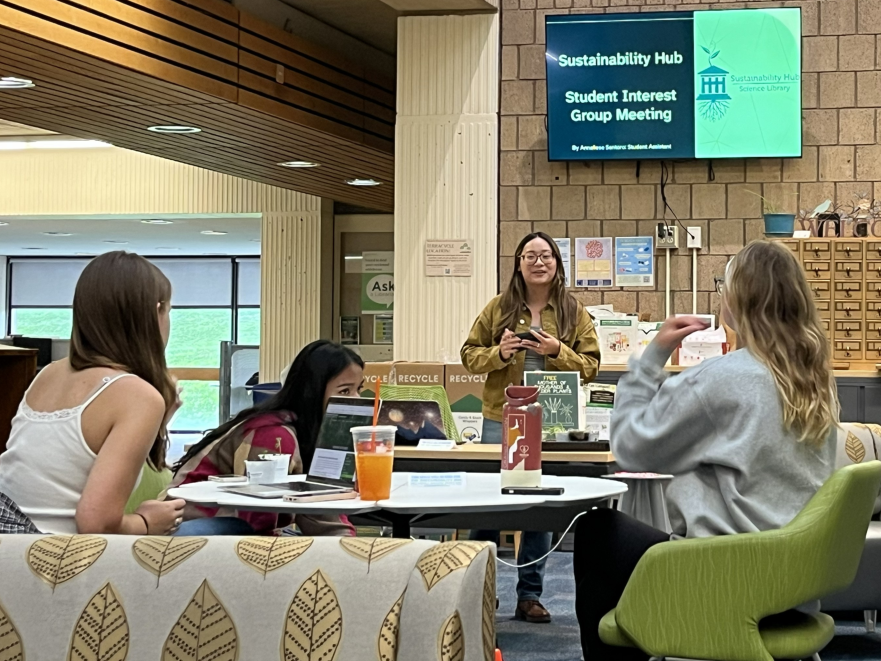 Annaliese Santoro stands in front of students gathered around a table at the Sustainability Hub.